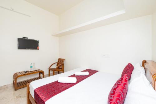 a bedroom with a bed and a tv on a wall at Bairava Bliss Inn in Rāmeswaram
