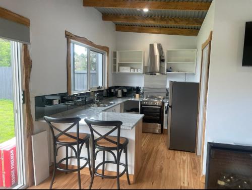 a kitchen with two bar stools at a counter at Acacia Hills Retreat in Acacia Hills