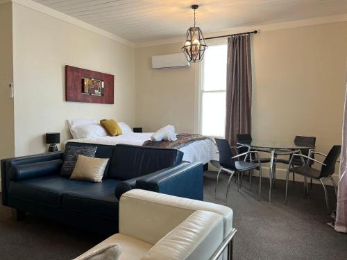una camera da letto con un letto, un divano e un tavolo di Beach Front Cottage Napier a Napier