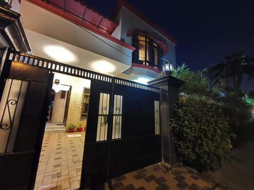 uma casa com uma porta de garagem preta à noite em Hotel Imperial Karachi em Carachi