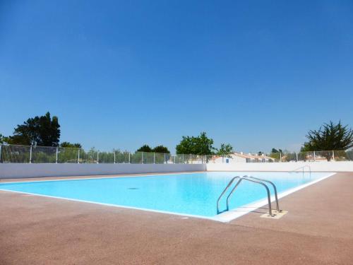 - une grande piscine avec une barre de maintien en métal à côté dans l'établissement Maison 2 pièces/mezzanine, piscines chauffée, tennis - Bretignolles-sur-Mer - FR-1-224A-666, à Bretignolles-sur-Mer