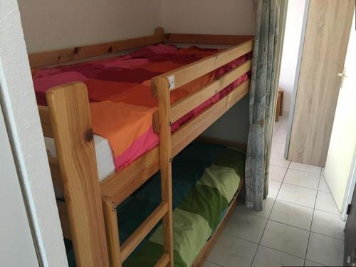 Ce lit superposé en bois se trouve dans une petite chambre. dans l'établissement Appartement Marseillan-Plage, 2 pièces, 6 personnes - FR-1-326-643, à Marseillan
