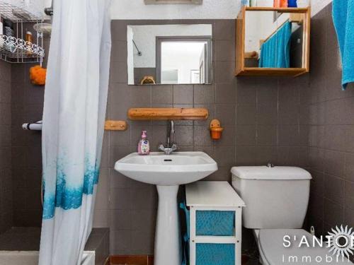 une salle de bain avec un lavabo, des toilettes et un miroir dans l'établissement Appartement 3 pièces climatisé au 1er étage, près du marché à Marseillan-Plage - FR-1-326-659, à Marseillan