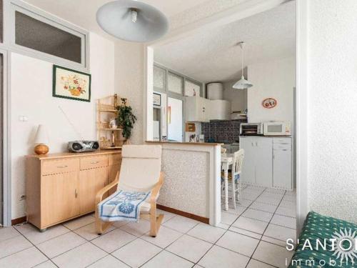 une cuisine avec une table et une chaise dans l'établissement Appartement 3 pièces climatisé au 1er étage, près du marché à Marseillan-Plage - FR-1-326-659, à Marseillan