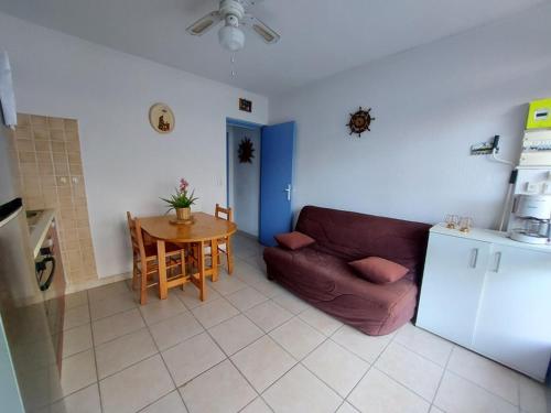 un salon avec un canapé et une table dans l'établissement Appartement T2 avec Grand Jardin, Terrasse et Parking - 4 Couchages à Marseillan Plage - FR-1-326-740, à Marseillan
