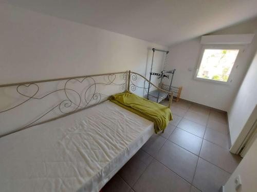 une chambre avec un lit avec une couverture jaune dessus dans l'établissement Maison climatisée en duplex, 2 chambres, terrasse, garage à 250m de la plage - FR-1-326-754, à Marseillan