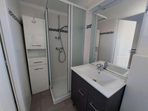 une salle de bain avec un lavabo et une douche dans l'établissement Maison climatisée en duplex, 2 chambres, terrasse, garage à 250m de la plage - FR-1-326-754, à Marseillan
