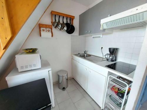 une petite cuisine avec un évier et une cuisinière dans l'établissement Studio Cabine Mezzanine, 6 Pers, Terrasse Sud, Près Quai, Parking Privé - FR-1-326-755, à Marseillan