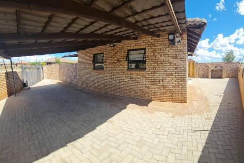 a brick building with a brick wall at HadedaOpiHoek in Postmasburg