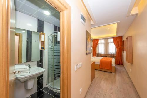 a bathroom with a sink and a shower and a bed at Hotel Devman in Istanbul