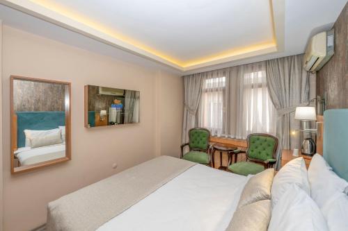 a hotel room with a bed and two chairs at Hotel Devman in Istanbul