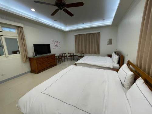 ein Hotelzimmer mit 2 Betten und einem Flachbild-TV in der Unterkunft Fun Hotspring in Jiaoxi