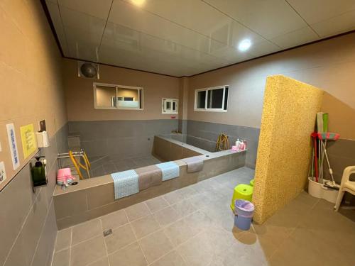 ein großes Bad mit einer Badewanne und einem Waschbecken in der Unterkunft Fun Hotspring in Jiaoxi