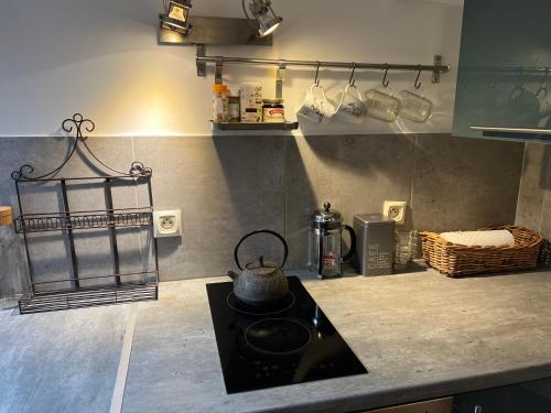 a kitchen with a tea kettle on top of a stove at Petit studio de la Maison du Bonheur - Rez de jardin in Villiers-sur-Marne