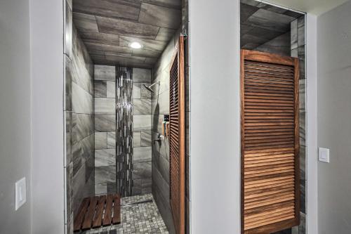 a walk in shower in a bathroom with a wooden door at Green Bay Getaway Near Lambeau Field and Resch! in Green Bay
