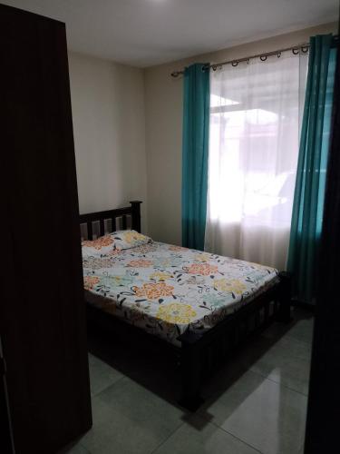 a small bed in a room with a window at Condominio in Cartago