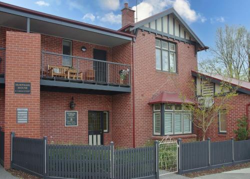 a red brick house with a fence in front of it at McKenzie House in Healesville
