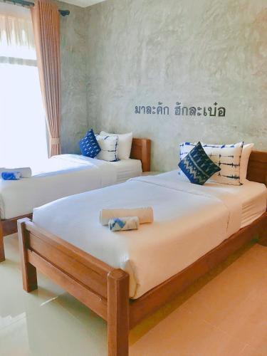 Postel nebo postele na pokoji v ubytování Hug Sakhonnakhon Hotel