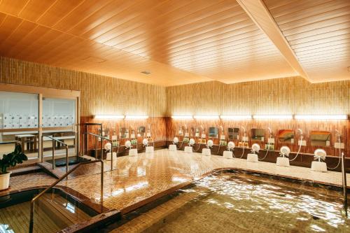 um quarto amplo com uma piscina com cadeiras em KAMENOI HOTEL Tondabayashi em Tondabayashi
