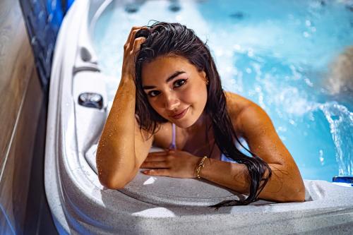 Una donna è seduta in una vasca da bagno di Seven Hotel Bytom - Katowice a Bytom