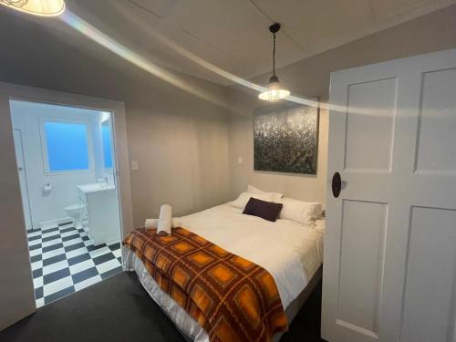 a bedroom with a bed and a white door at Beach Front Studio Napier in Napier