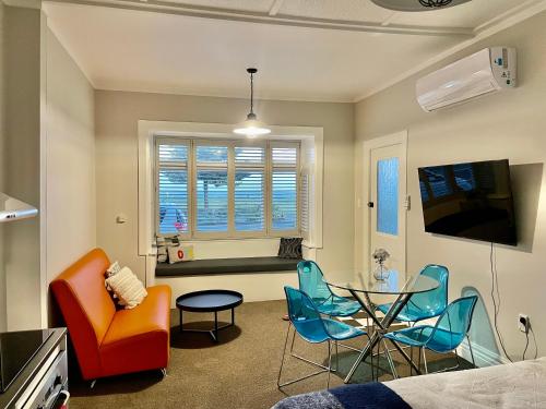una sala de estar con una mesa y sillas en Beach Front Studio Napier, en Napier