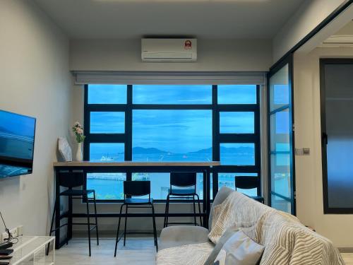 a living room with a table and chairs and a large window at JESSELTON QUAY SEAVIEW Can Request LateCheckout 2pm in Kota Kinabalu