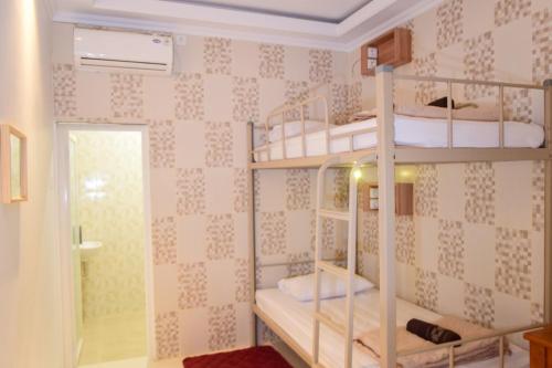 a room with three bunk beds in a room at The Cabin Purwokinanti Hotel in Yogyakarta