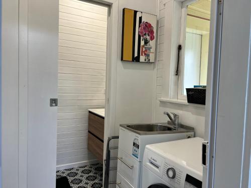 a small bathroom with a sink and a washing machine at Rotorua Holiday Villa in Rotorua