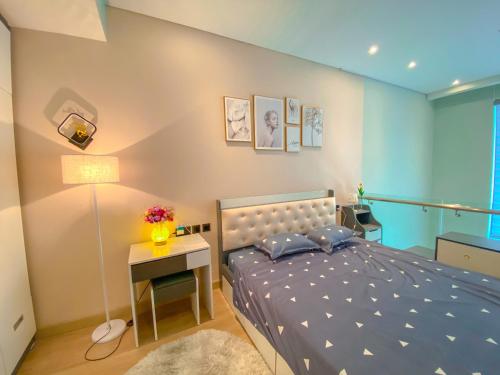 1 dormitorio con 1 cama y 1 mesa con lámpara en Sea View Sandy homestay Citadines Marina Ha Long en Ha Long
