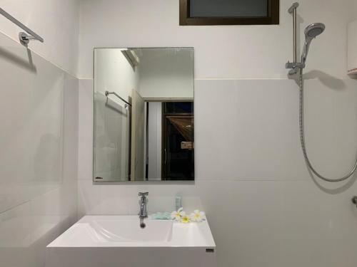 a white bathroom with a sink and a mirror at Koh Jum Paradise Resort in Ko Jum