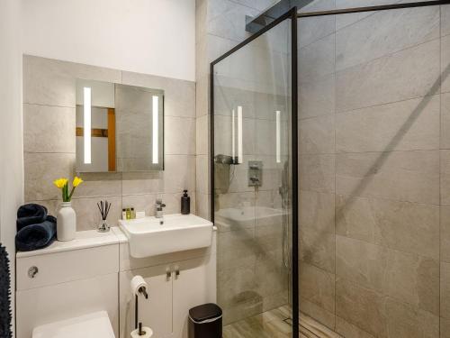 W łazience znajduje się umywalka i przeszklony prysznic. w obiekcie Bramley Cottage w mieście North Weald