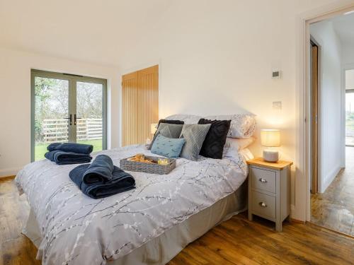 um quarto com uma cama com toalhas azuis em Bramley Cottage em North Weald