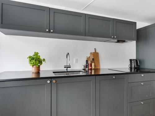 a kitchen with gray cabinets and a sink at Regent 4- Cute 1-Bdr Apt in Centre of Copenhagen in Copenhagen