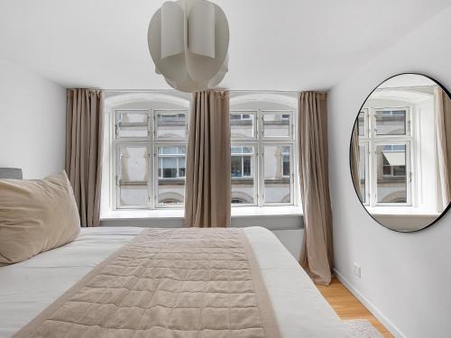 1 dormitorio con 1 cama grande y espejo en Sanders Regent - Endearing One-Bedroom Apartment Near Central Square, en Copenhague