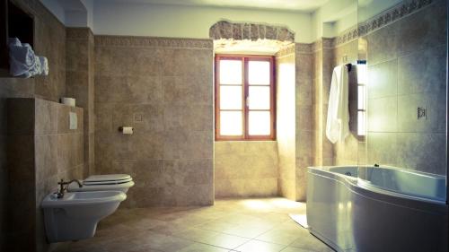 Dobrinj的住宿－Villa Rustica，一间带卫生间和浴缸的浴室以及窗户。