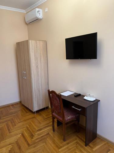 a room with a desk and a cabinet and a television at Villa Magda in Berehove