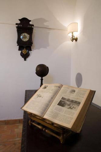 a book on a table with a clock on the wall at Relais Villa Giusso in Vico Equense