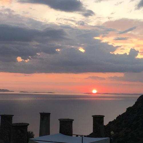 a sunset over the water with the sun in the sky at Relais Villa Giusso in Vico Equense