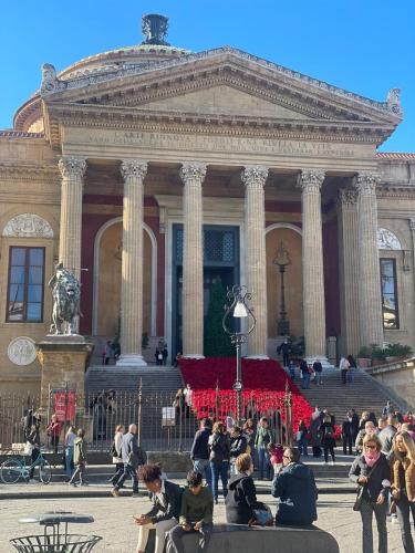 a group of people sitting in front of a building at Gioiamia - Luxury Rooms in Cattedrale in Palermo