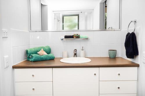 a bathroom counter with a sink and a mirror at Emohruo Rainbow Shores - 3 Br Resort Apartment in Rainbow Beach