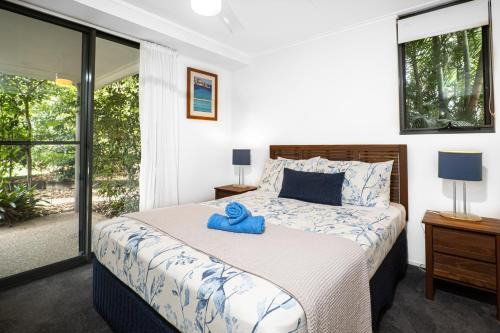 a bedroom with a bed with a blue towel on it at Emohruo Rainbow Shores - 3 Br Resort Apartment in Rainbow Beach