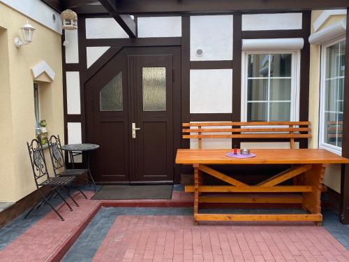 a wooden bench sitting in front of a door at Ferienwohnung Kormoran in Helmstedt
