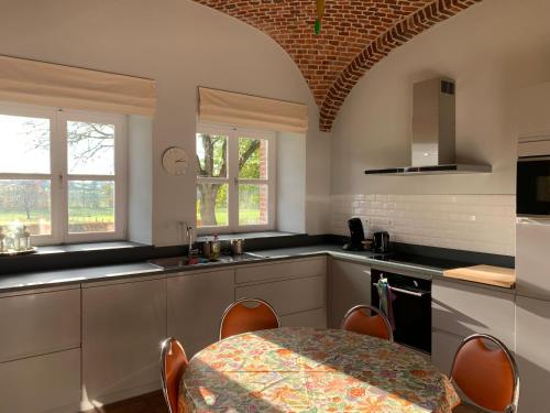 a kitchen with a table and a dining room at La Bergerie, gîte à la ferme, 3 épis in Walcourt