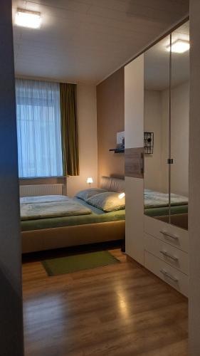 - une chambre avec un lit et un grand miroir dans l'établissement Ferienwohnung Christa, à Graz