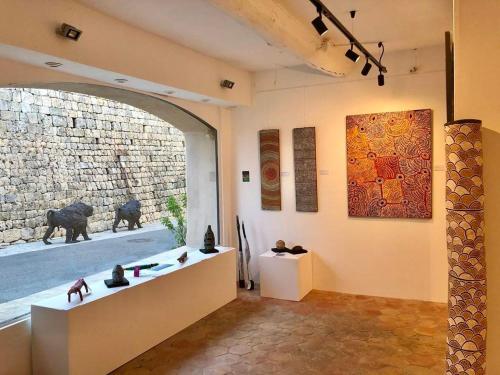 a museum room with a large window and a stone wall at Mougins Collection - Magnifique maison au Cœur du Vieux Village de Mougins, vue sur les Alpes du Sud in Mougins