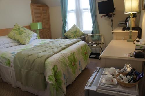 a bedroom with a bed and a table with a tray at Amazon Guest House in Oxford