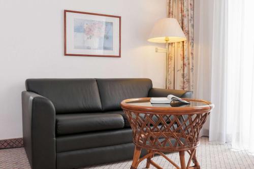 uma sala de estar com um sofá e uma mesa em Wyndham Garden Donaueschingen em Donaueschingen
