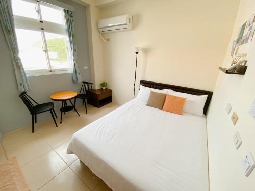1 dormitorio con cama, mesa y ventana en 綠島夏御 微熱海岸, en Isla Verde