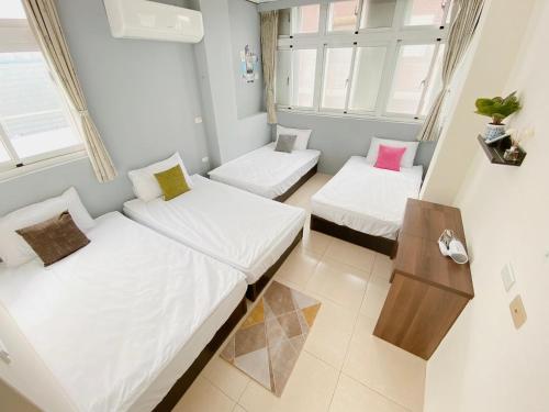 Habitación pequeña con 2 camas y mesa. en 綠島夏御 微熱海岸, en Isla Verde